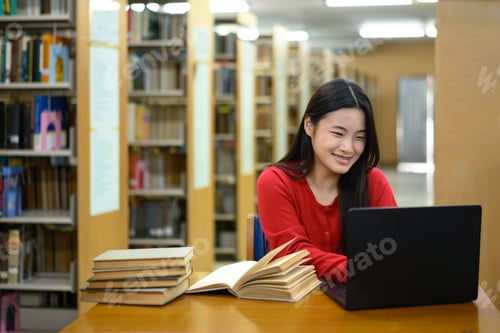 Preview: Teenage girl education concept. Her using laptop in library