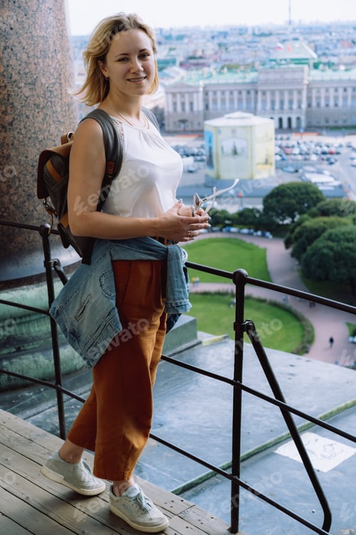 Preview: Young woman standing at collonade of Saint Isaac cathedral in Saint Petersburg, Russia