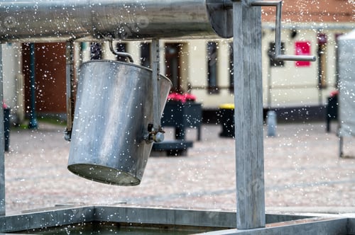 Preview: A metal bucket on a fountain in the city. Background with selective focus and copy space.