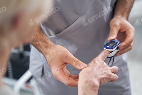Preview: Doctor applying pulse oximeter to patient finger