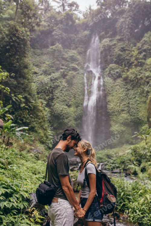 Preview: Affectionate young couple standing together in forest