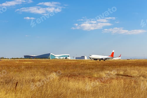 Preview: Passenger plane taking off from runway at airport on sunny day