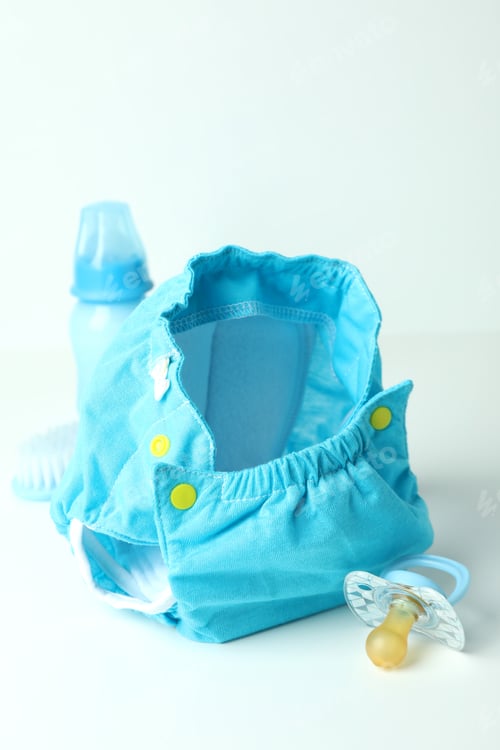 Preview: Concept of baby clothes with reusable diapers on white table