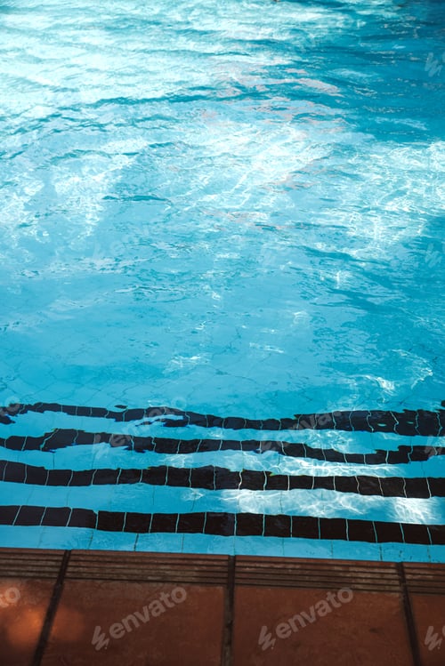 Preview: Stairs leading into depths of pool, clear water with ripples. Summer background, vacation concept