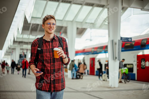 Young Man at Train Station with Takeaway Coffee