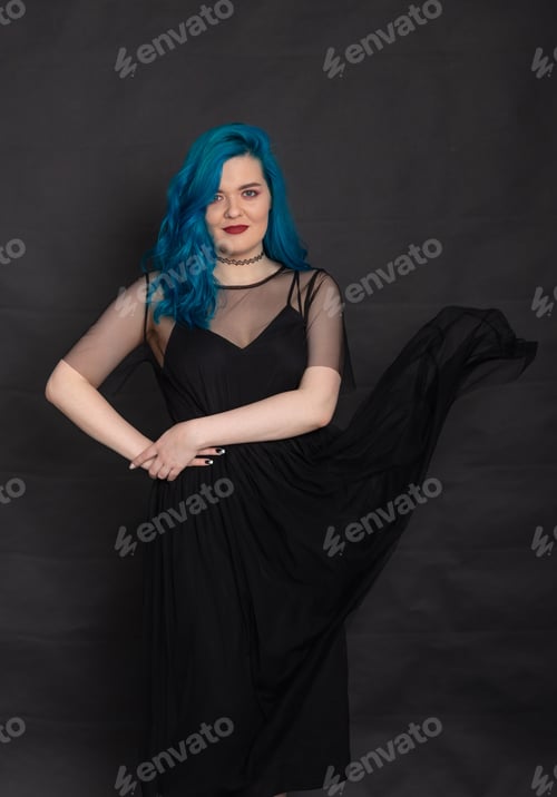 Preview: People and fashion concept - Woman dressed in black dress and blue hair posing over black background