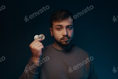 Preview: A young man with a bitcoin in his hands. Cryptocurrency.