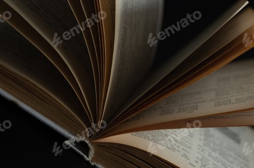 Preview: Open book with pages on a black background.