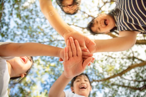 Visualização: Conceito de unidade. Vista inferior de crianças pequenas juntando as mãos