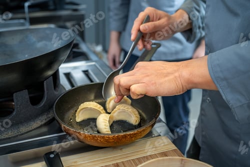 Preview: Chef pan-frying dumplings in a professional kitchen setting