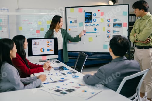 Preview: Asian businesswoman leading meeting and giving presentation using whiteboard