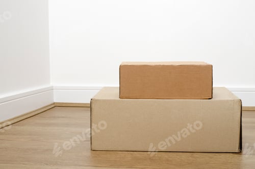 Preview: Empty room with stack of cartons: moving house concept. Moving in concept. Two different size boxes