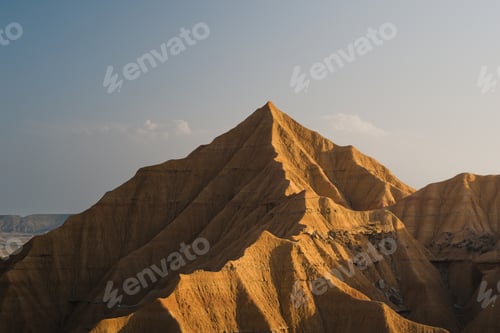Preview: Warm sunlight bathes a prominent peak in the bardenas reales desert,