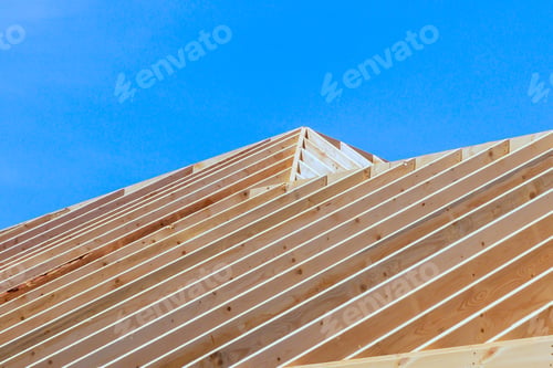 Preview: New frame building is under construction with rafters, roof beams, a construction framework