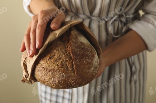 Preview: Woman in apron hold fresh baked bread