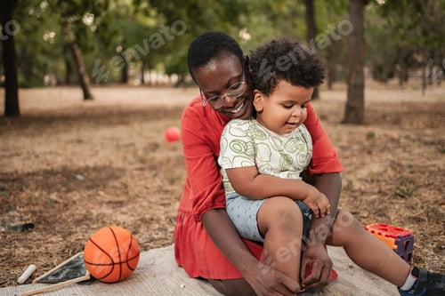 Preview: Mother tying her son's shoes in the park
