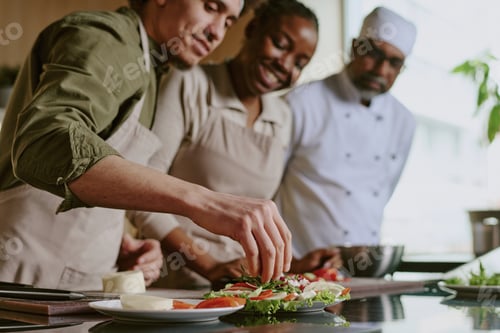 Preview: Male Sous chef Adding Condiment into Dish