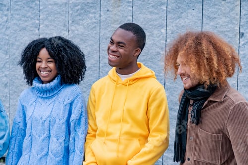 Preview: Three friends laughing together against a wall