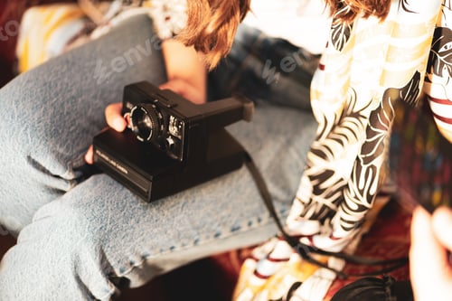 Preview: Young lady holding old Polaroid camera
