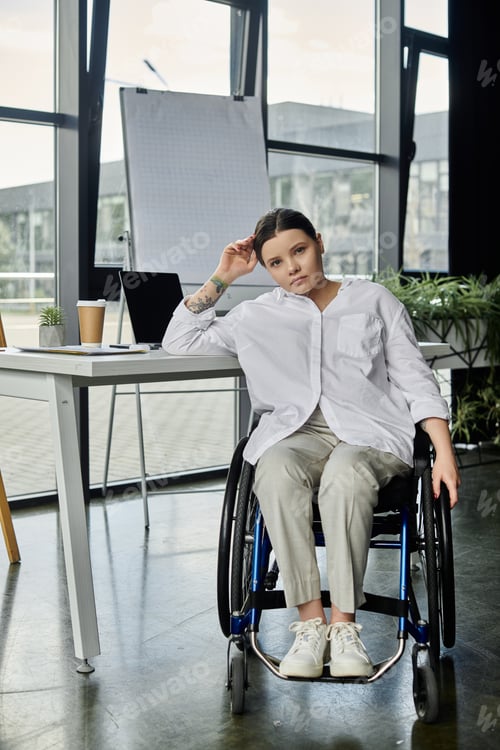 Preview: Young businesswoman in wheelchair working in modern office