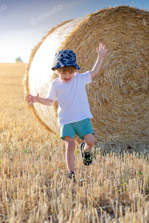Preview: Boy in Field Plays Near Hay Bale