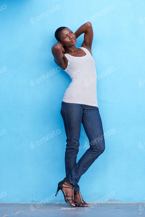 Preview: black woman leaning against blue wall with hands behind head