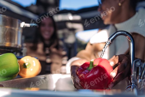 Preview: washing red pepper in the sink of a camper van