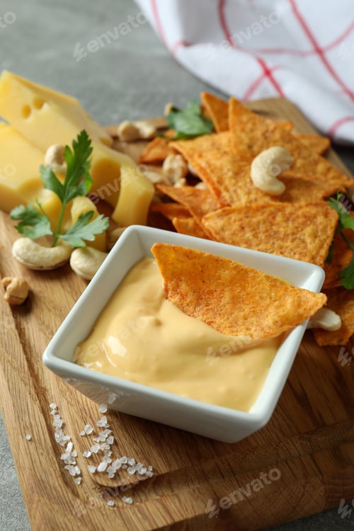 Preview: Board with cheese sauce and snacks, close up