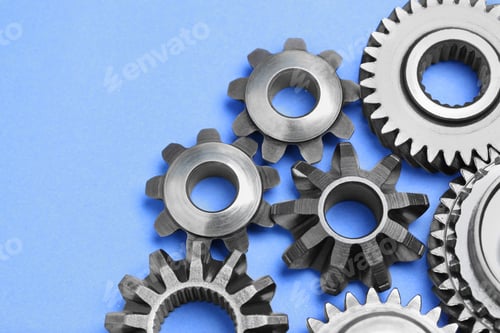 Preview: Different stainless steel gears on light blue background, above view. Space for text