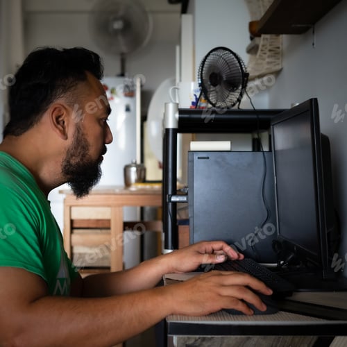 Preview: bearded matured asian man using computer at home. working from home during quarantine