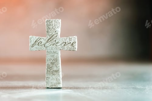 Preview: Stone cross with inscription Believe on grey background, Copy space. Christian backdrop. Biblical