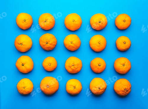 Preview: Ripe bright orange tangerines on blue background, fruit pattern. Top view