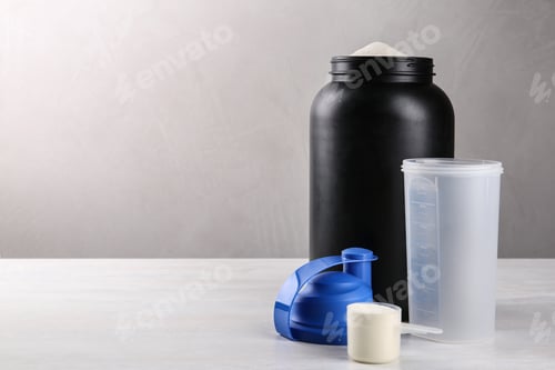 Preview: Composition with measuring scoop of protein powder on white table. Space for text