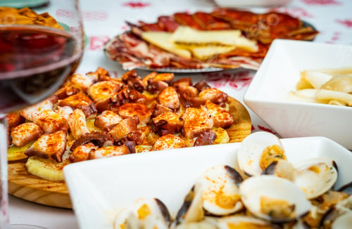 Preview: Closeup of cooked seafood with spices and a sausage platter with cheese on the table