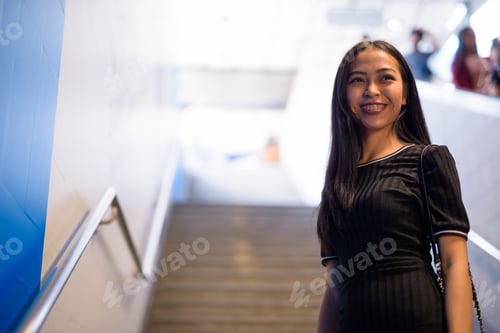 Preview: Happy young beautiful Asian tourist woman at the subway station