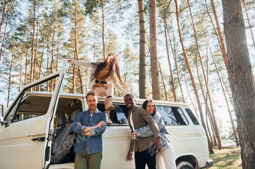Preview: Destination place. Group of young people is traveling together in the forest at daytime