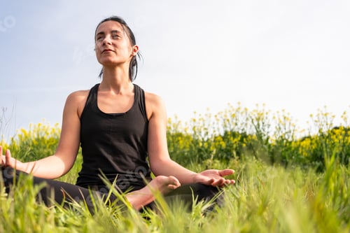 Preview: girl practicing yoga in nature with fit clothes in summertime