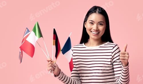 Preview: Asian Female Sitting With International Flags And Laptop And Showing Thumb Up