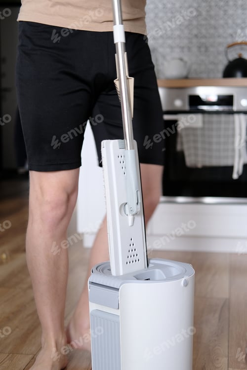 Preview: Man drying mop in modern bucket