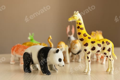 Preview: Children's plastic toys panda and giraffe stand in the foreground on the table