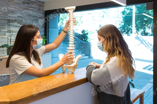 Preview: Physiotherapist showing and pointing the spinal hernia to patient