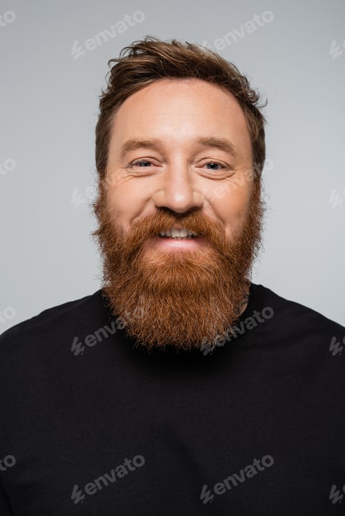 Preview: portrait of joyful man with beard smiling at camera isolated on grey