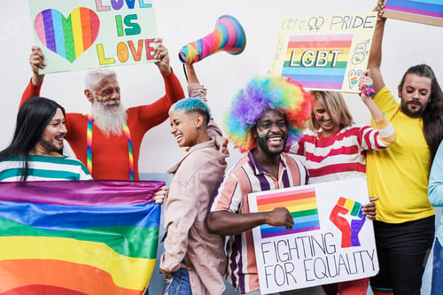 Preview: People dancing at gay pride parade with rainbow flags and banner - Homosexual love and lgbt concept