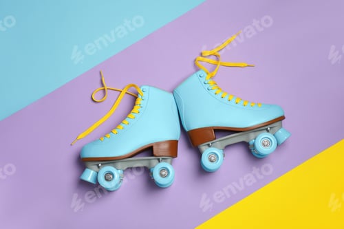Preview: Pair of stylish quad roller skates on color background, top view