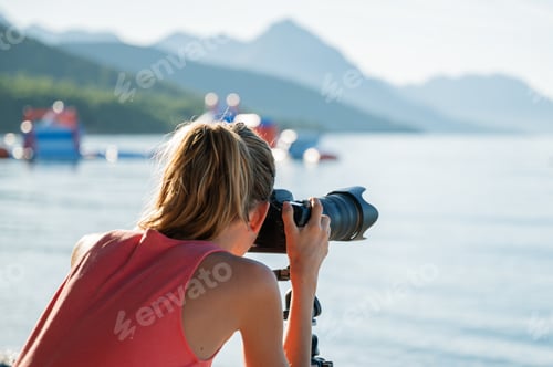 Preview: Female photographer taking photos of beautiful sea and landscape