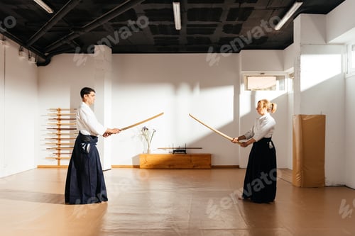 Preview: Two Martial Artists Engaging in Sword Practice at a Dojo During Daylight