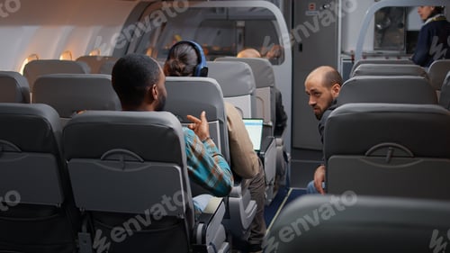 Preview: Diverse travellers having conversation in airplane before takeoff