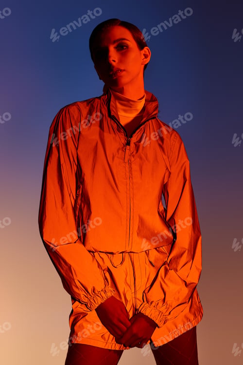 Preview: Trendy woman poses elegantly in a stylish outfit against a vibrant backdrop