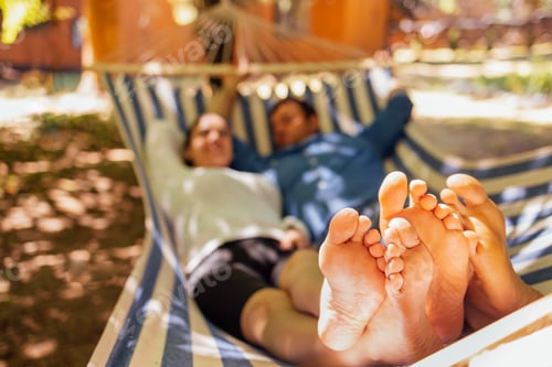 Preview: Relaxing Couple Lies in Striped Hammock Outdoors