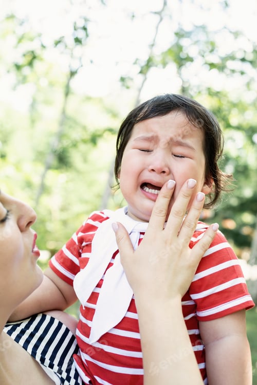 Preview: Young mother with infant daughter. Mother calming crying kid